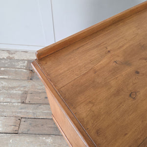 Antique pine chest of drawers with four graduating drawers, low upstand and brass swan neck handles
