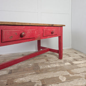 Rustic antique pine table with vibrant red-painted base and two drawers
