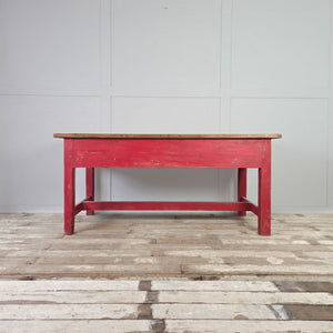 Large antique pine kitchen table with red base and turned wooden knobs
