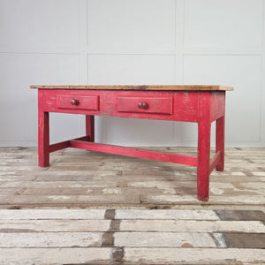 Large antique farmhouse kitchen table with red base and scrubbed pine top
