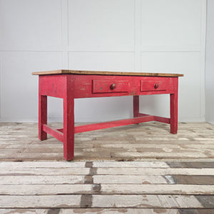 Rustic antique pine table with vibrant red-painted base and two drawers
