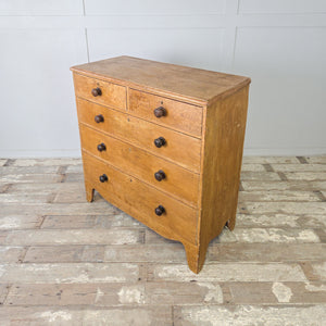 Antique five drawer pine chest with dark oak knobs contrasting against mustard painted finish
