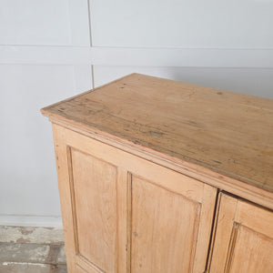Georgian pine storage cupboard with fielded panelled doors, moulded cornice, and a clear waxed finish to the pine.
