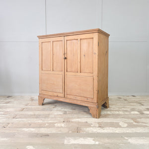 Waxed pine two door cupboard from the Georgian period, with panelled doors and three tiers of interior storage.

