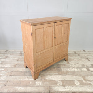 Georgian country pine cupboard with panelled doors opening to generous shelved storage, sealed in a clear wax.
