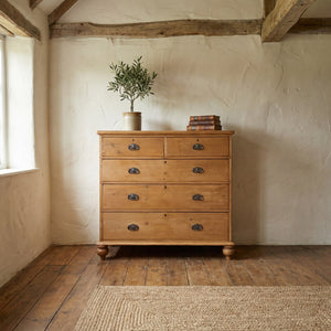 A large antique Victorian pine chest of drawers, fitted throughout with original Art Nouveau handles and raised on four turned bun feet

