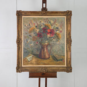 A beautifully large vintage floral oil painting depicting wildflowers arranged in a copper pitcher, painted in an expressive impasto style and housed in a decorative gilt frame
