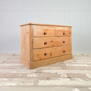 19th century pine chest of drawers with two smaller drawers over two full-width drawers and wooden knob handles.