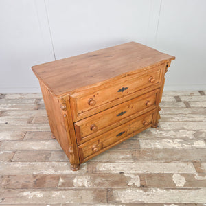 Early 20th century antique pine dresser chest with three storage drawers and decorative carved detailing.
