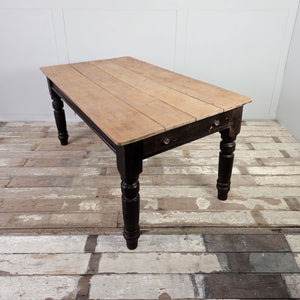 Victorian dining table from the 19th Century with a planked sycamore top and dark painted pine base, including a single drawer.
