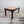 Antique Victorian farmhouse dining table with a planked sycamore top and dark painted pine base, featuring chunky turned legs and a single drawer with glass knobs.