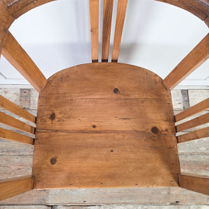 Rustic pine tub chairs, early 20th century, sold as a matching pair with barrel-back silhouette, continuous curved rail, slatted sides and back, deep seats and square-set legs.
