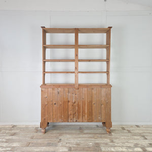 Victorian pine dresser with open display shelving above and three drawers with wooden knobs
