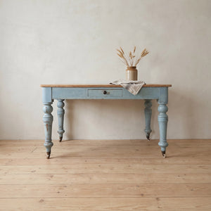 A Victorian pine farmhouse table with a pale blue painted base and stripped three-plank pine top, dating from the 19th century.
